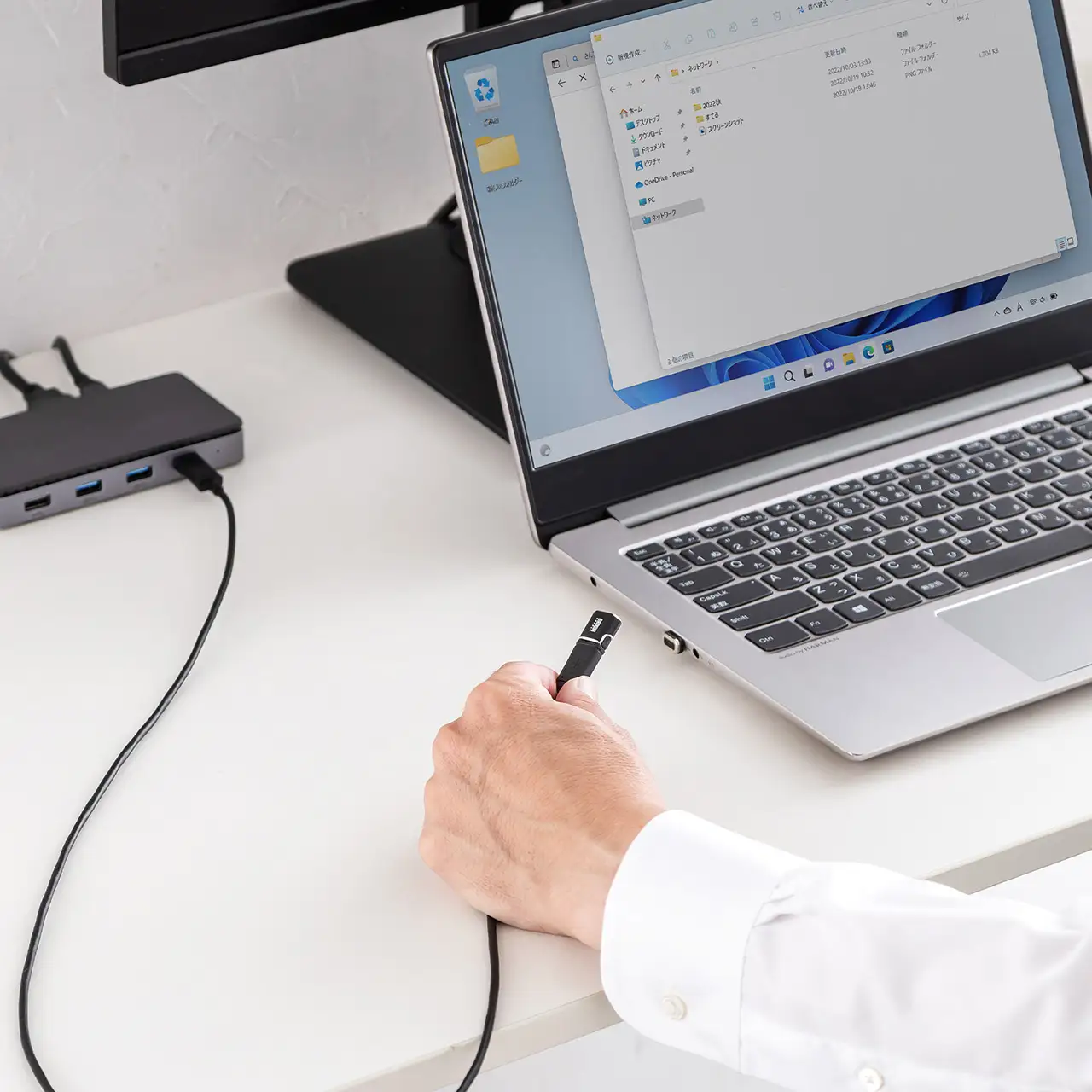 ノートPCに挿した500-USB110BKへケーブル側を近づけるメーカー使用イメージ