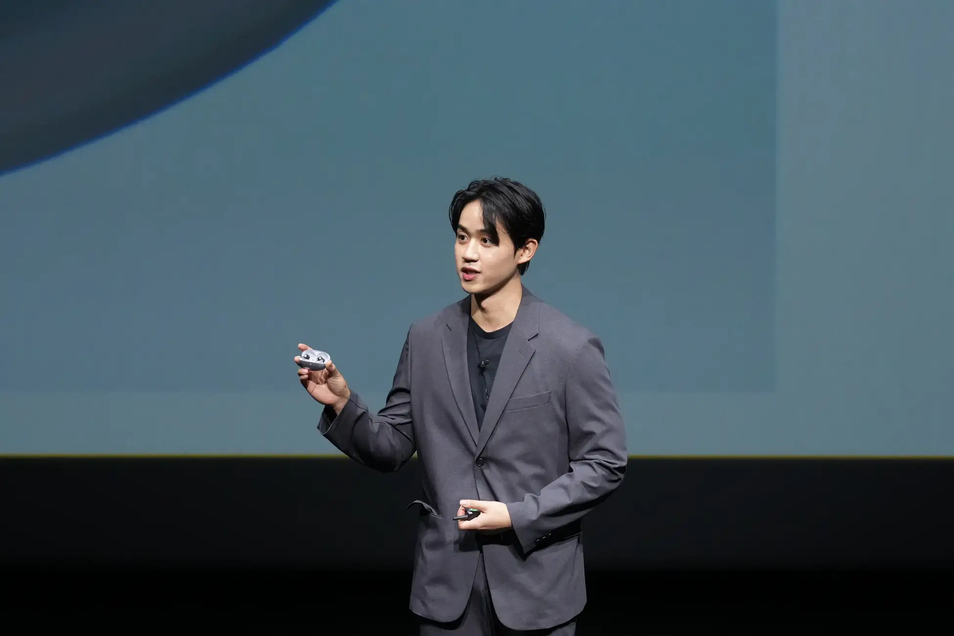 公式発表会でHUAWEI FreeBuds Neoのイヤホンとケースを紹介する様子