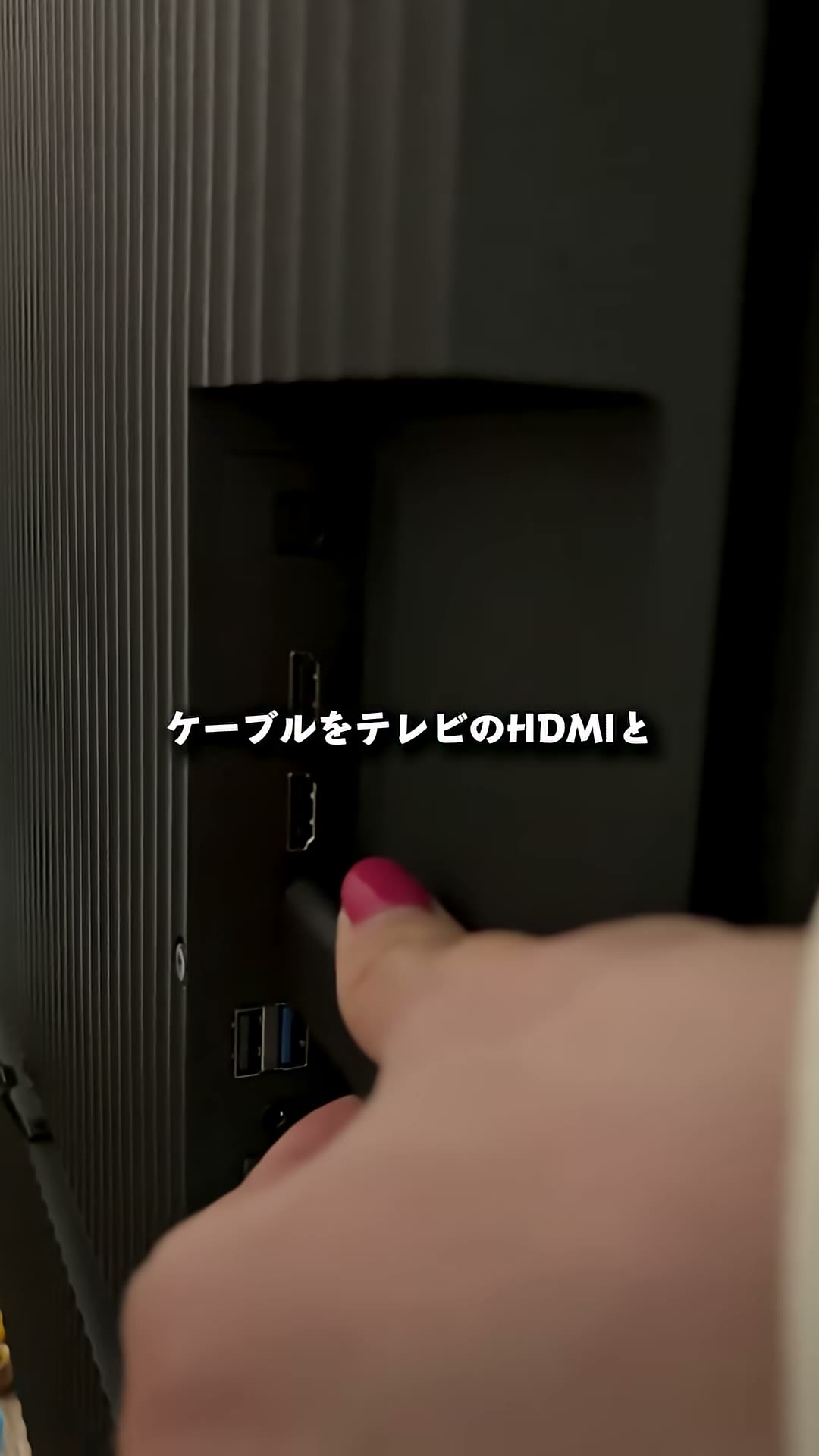 テレビ背面のHDMI端子にケーブルを接続している様子
