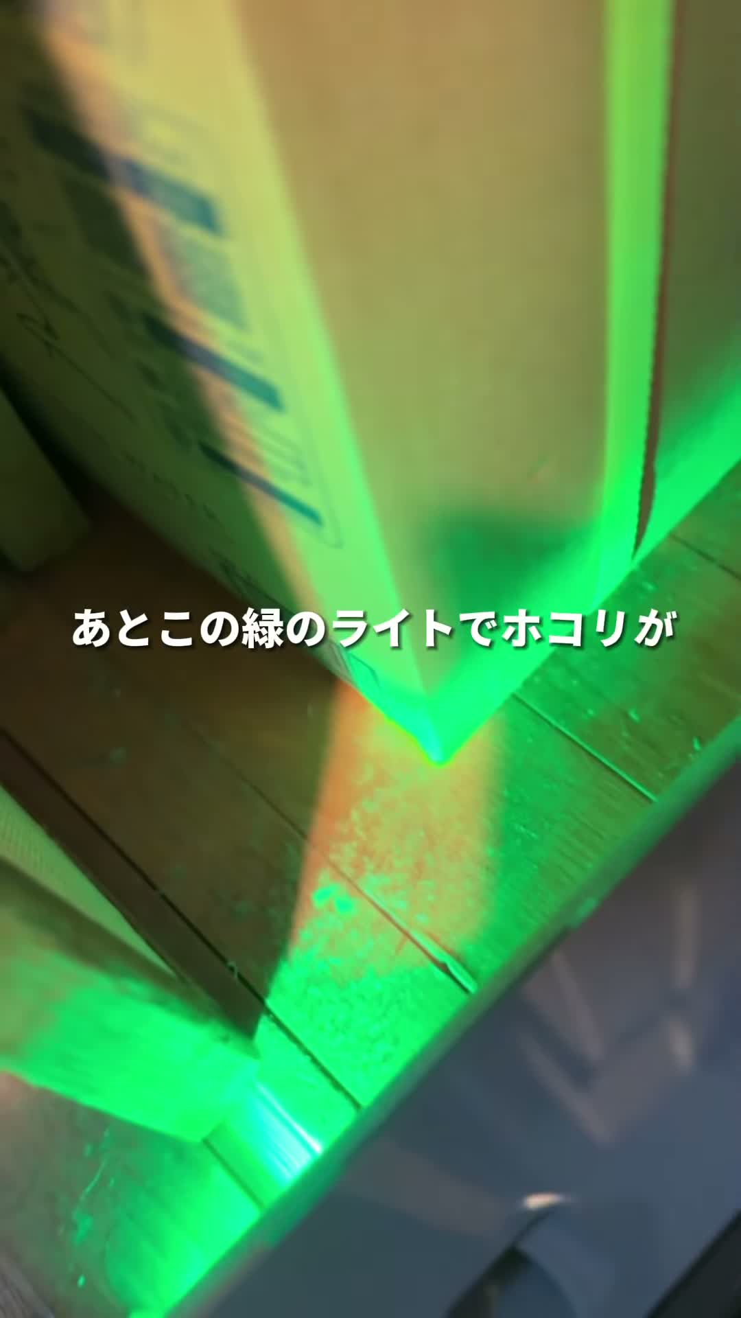 緑のライトで床のホコリが照らされている様子